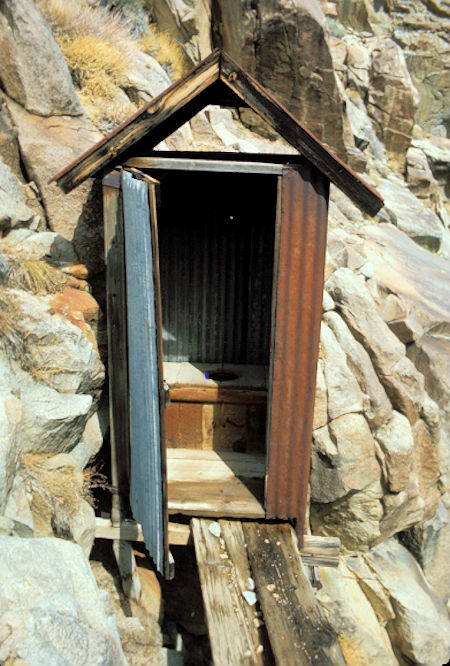 Outhouse perched on side of cliff