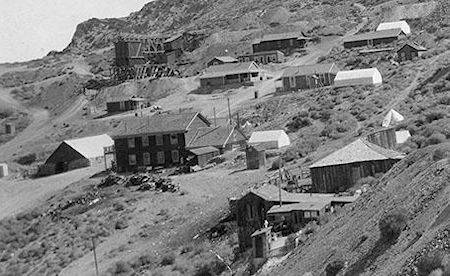 At top just right of center is Lola's dance hall with the girl's cribs below and the roof of the Assay Building just visible. The building below is gone. Slightly below is the Belshaw House with a white tent next to it where the Gordon House was later built. Center left is the American Hotel. At the bottom right is the Hunter House.