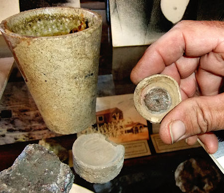 Extracting silver: A crucible (top left) is used to smelt the silver-bearing galena (lead sulfide, bottom left corner) into a form that can be super-heated to 900 degrees in a cupel (a porous cup made of bone ash, bottom), at which point the lead oxides and the silver separates out to form a "button" (at right)