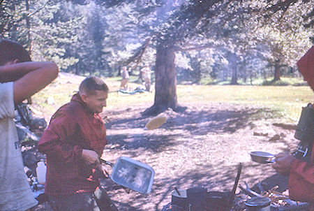 It's in the air, Bob Brooks flipping pancakes at Hutchinson Meadow camp - John Muir Wilderness 17 Aug 1962