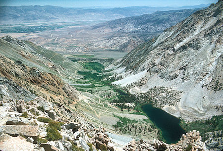 Horton Lake from the saddle above Hanging Valley on the way to Peak 12224. The beginning of the road to Hanging Valley can be seen as it starts up the slope from the lake - 10 Jul 1977