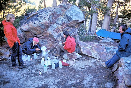 Paul Robotta cooks supper while Curt Sayer, Brian Twohey and Kevin Twohey look on
