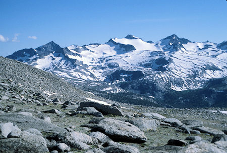 View southwest from the Kuna Crest of Mt. Lyell and its large glacier in the center, Mt. Maclure on the right. The pointed peak on the left may be Electra Peak. In the foreground is the head of the Lyell Canyon near Donohue Pass