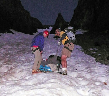 Descending the snow field while attending to the injured hiker